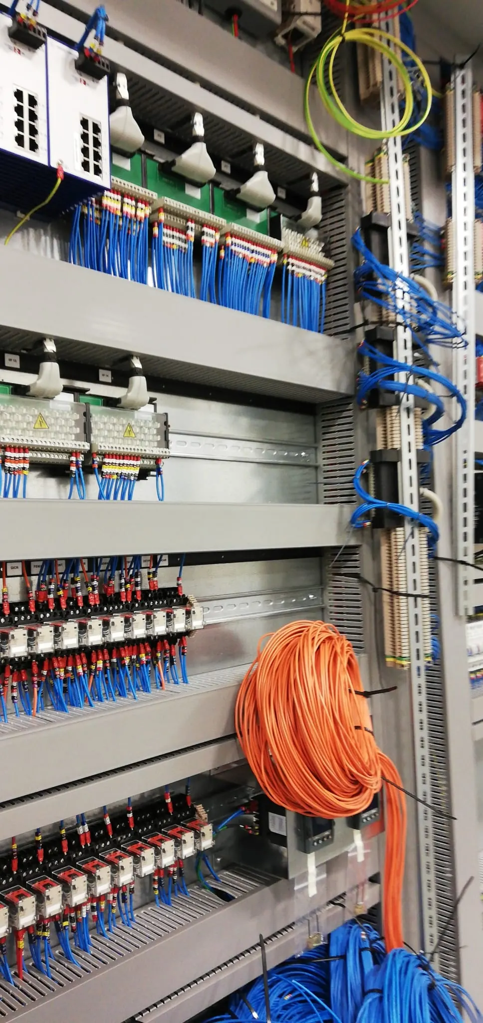 Terminal blocks with blue wiring and an orange cable loop