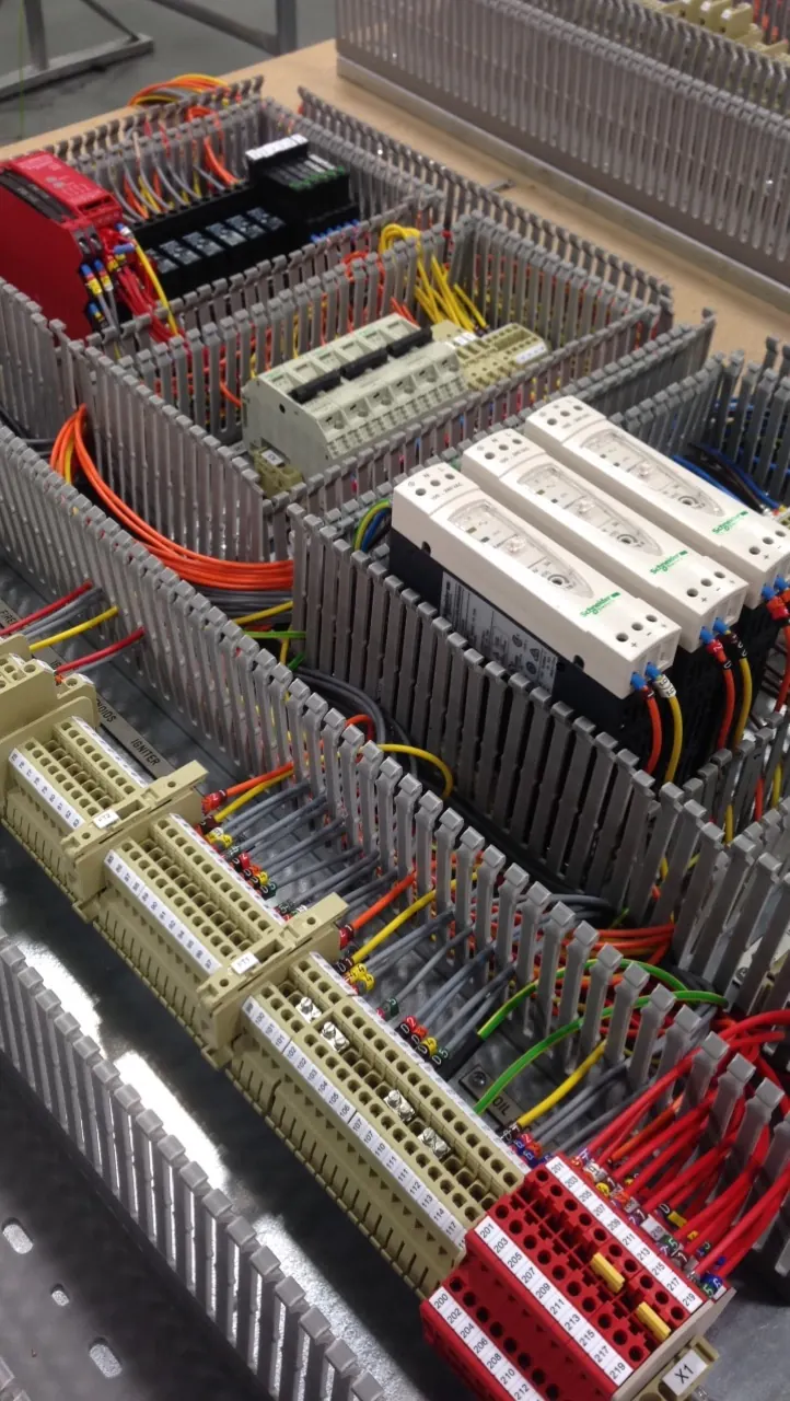 Power supplies, terminals and wiring in grey trunking inside a control panel